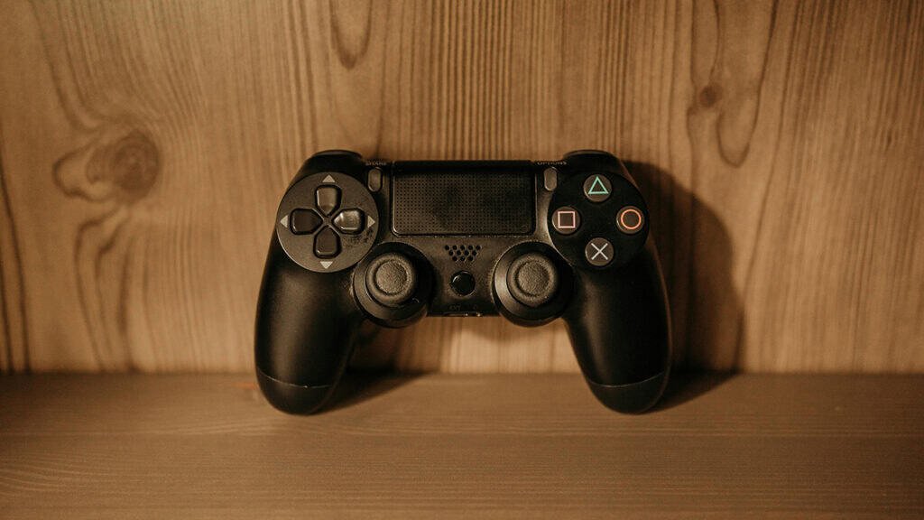 PlayStation controller on a wooden desk symbolizing the gaming industry’s technological plateau